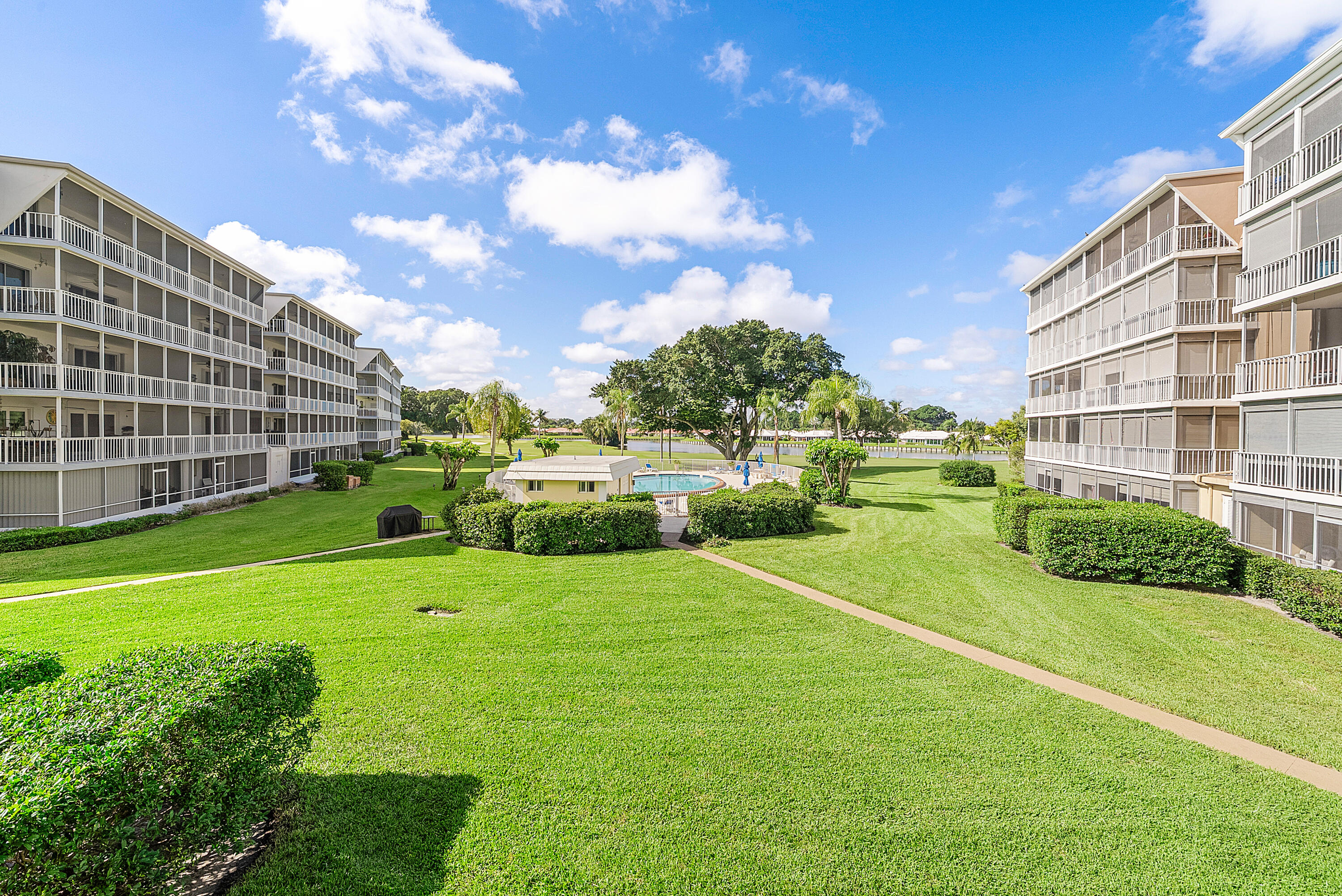 145 Atlantis Boulevard, Unit 203 Atlantis, FL 33462 - Photo 21 of 33 a view of a garden with a building and a big yard