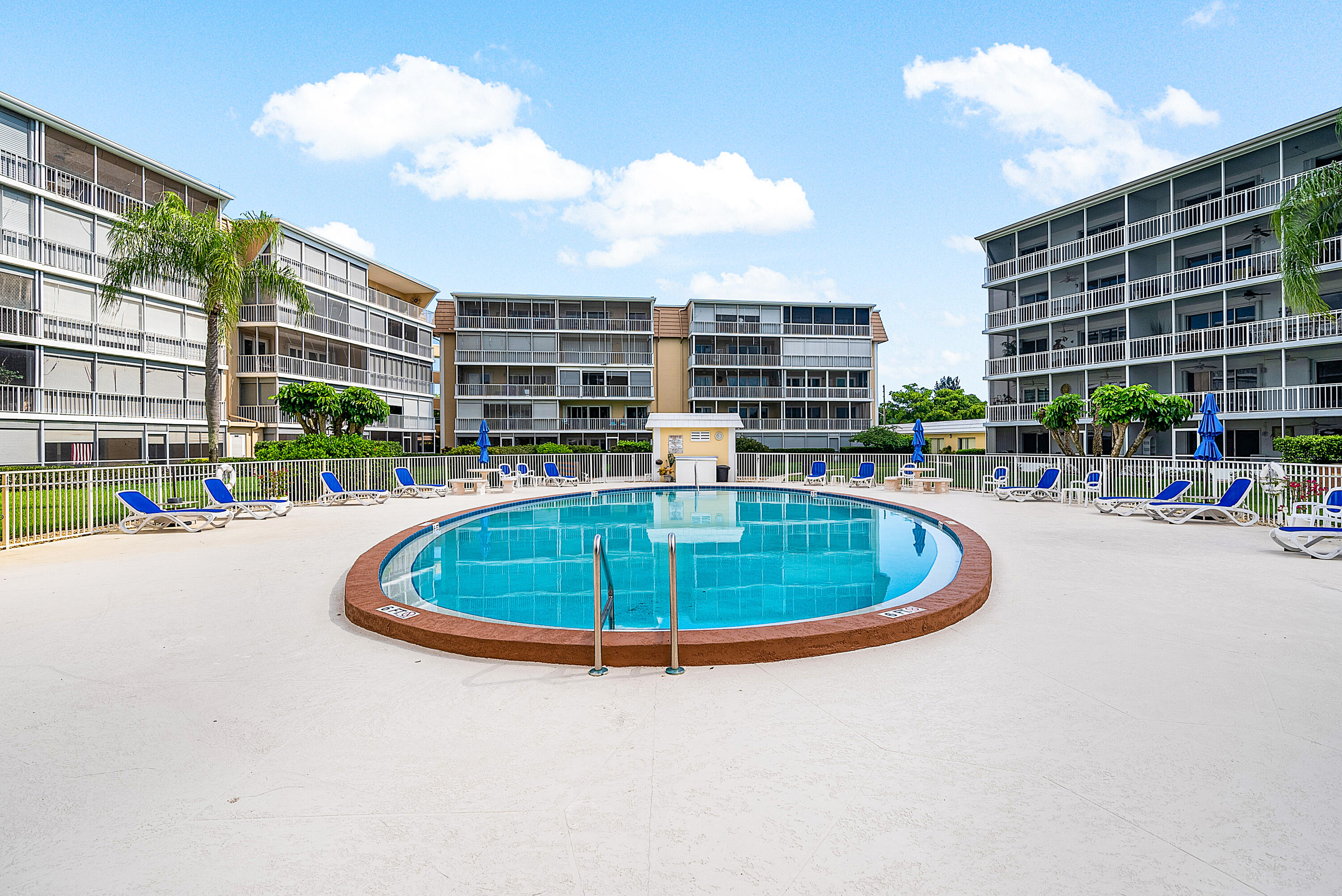 145 Atlantis Boulevard, Unit 203 Atlantis, FL 33462 - Photo 26 of 33 a swimming pool with outdoor seating and buildings in the back