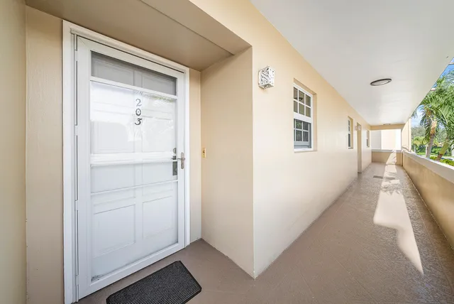 a view of a hallway with white walls and stairs
