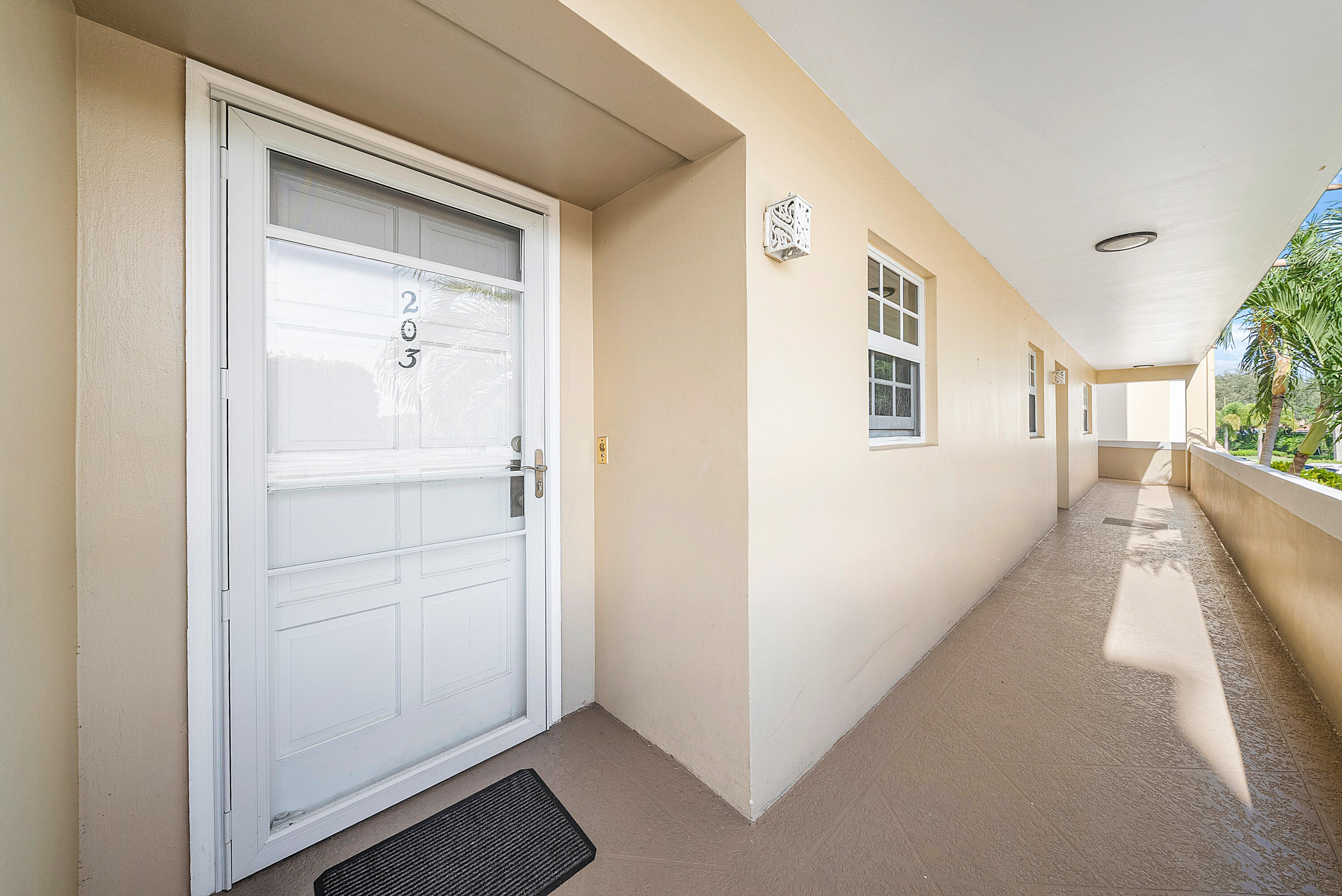 145 Atlantis Boulevard, Unit 203 Atlantis, FL 33462 - Photo 3 of 33 a view of a hallway with white walls and stairs