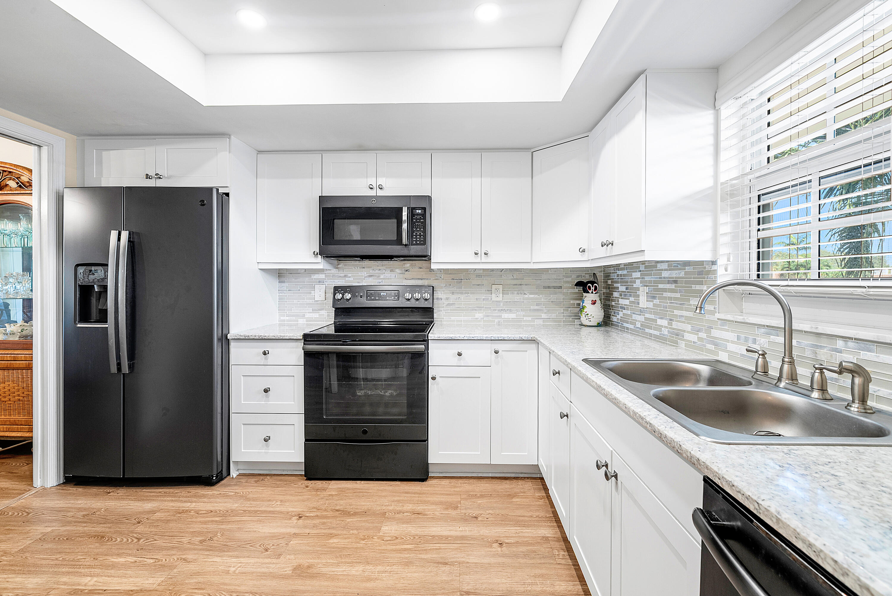 145 Atlantis Boulevard, Unit 203 Atlantis, FL 33462 - Photo 5 of 33 a kitchen with a sink stove and refrigerator