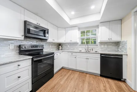 a kitchen with granite countertop a stove sink and microwave