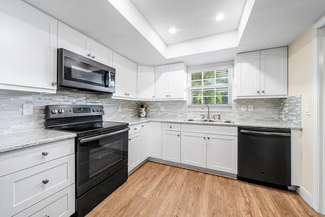 a kitchen with granite countertop a stove sink and microwave