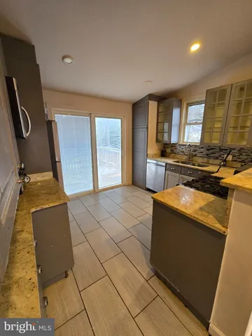 a view of a kitchen with fridge and wooden floor