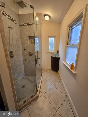 a bathroom with a glass shower door and a window