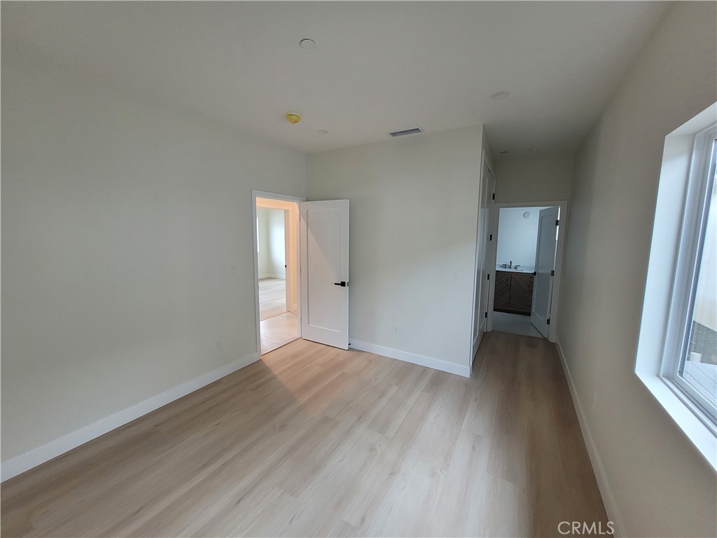 19453 Strathern Street Reseda, CA 91335 - Photo 11 of 12 a view of an empty room with a window and wooden floor
