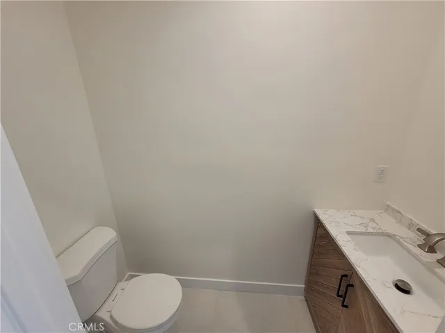 a bathroom with a granite countertop toilet and a sink