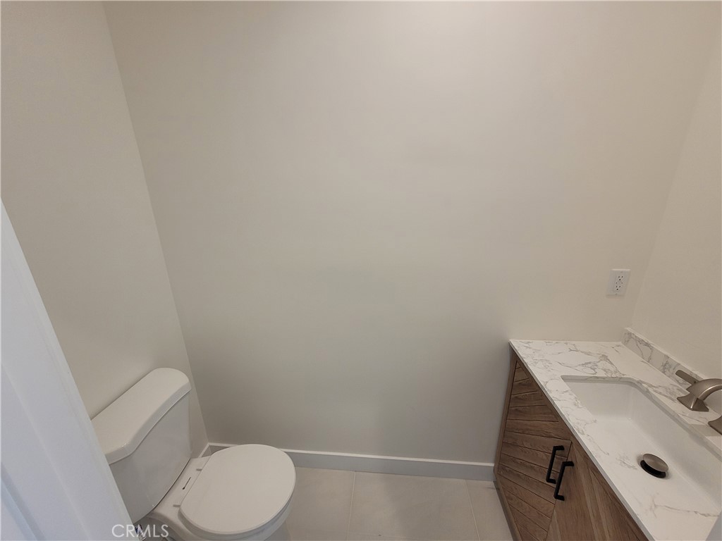 19453 Strathern Street Reseda, CA 91335 - Photo 6 of 12 a bathroom with a granite countertop toilet and a sink