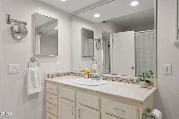 a bathroom with a sink vanity and a mirror