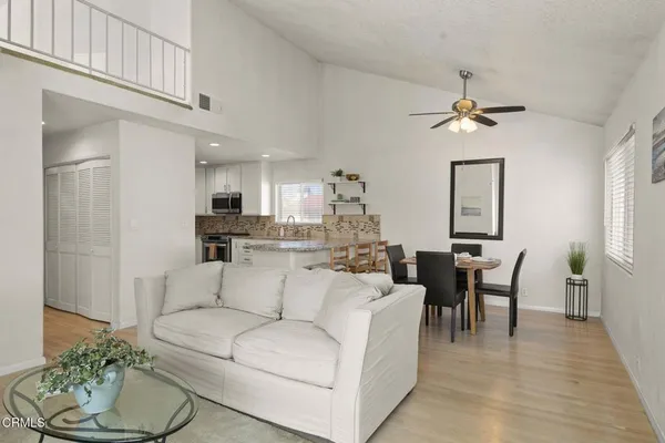 a living room with furniture a dining table and a chandelier