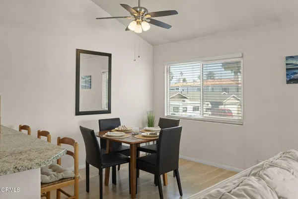 a view of a a dining room with furniture window and wooden floor