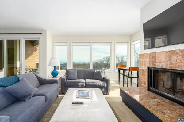 a living room with furniture a flat screen tv and a fireplace