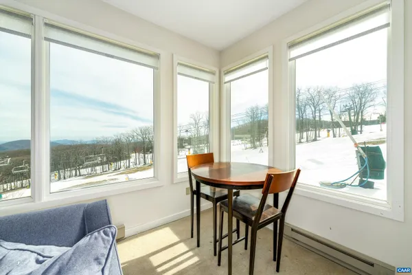 a table and chairs in a room next to a window