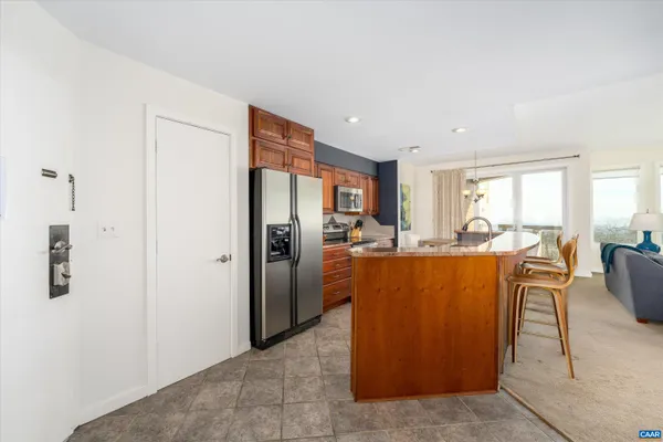 a living room with furniture a large window and stainless steel appliances