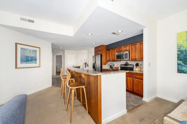a kitchen with stainless steel appliances granite countertop a refrigerator and a stove top oven