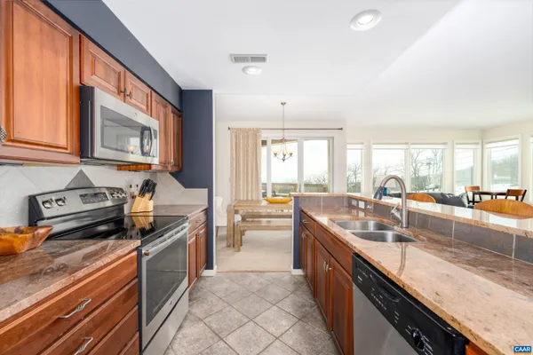 a large kitchen with stainless steel appliances granite countertop a lot of counter space and a sink