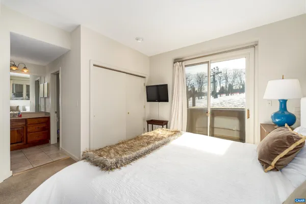 a bedroom with a bed and a large window