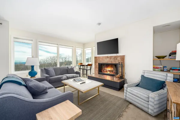 a living room with furniture fireplace and a large window
