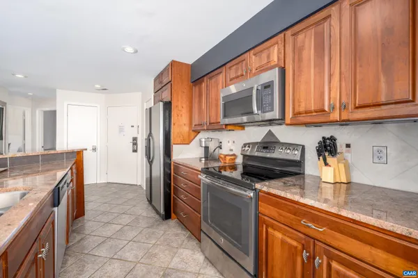 a kitchen with stainless steel appliances granite countertop a stove a sink and a refrigerator