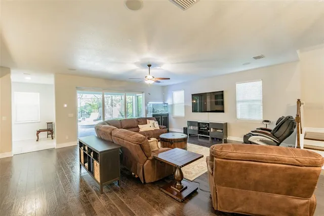 a view of a dining room with furniture a chandelier and wooden floor