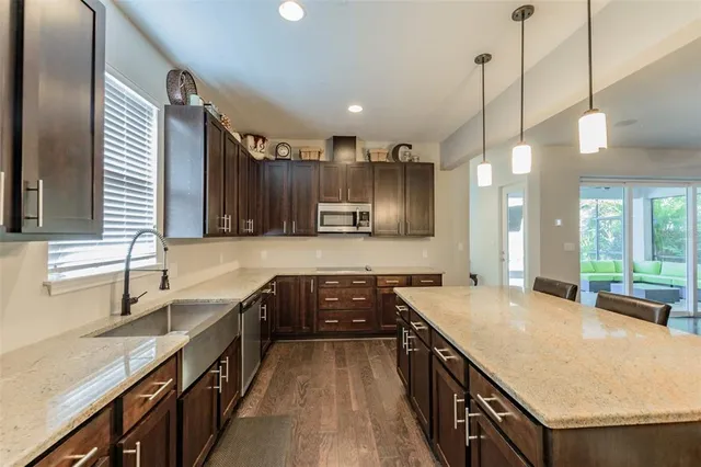 a kitchen with a table chairs microwave and refrigerator