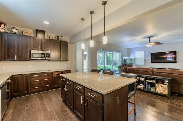 a kitchen with kitchen island a sink stove and wooden floor