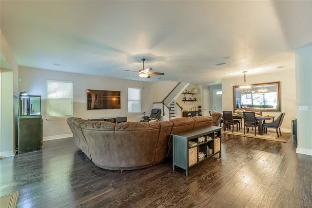 a living room with furniture a flat screen tv and wooden floor
