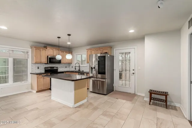a kitchen with stainless steel appliances granite countertop a refrigerator and a stove top oven
