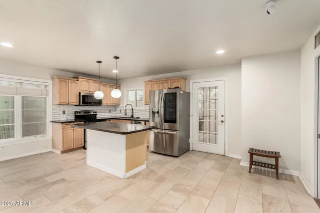 a kitchen with stainless steel appliances granite countertop a refrigerator and a stove top oven