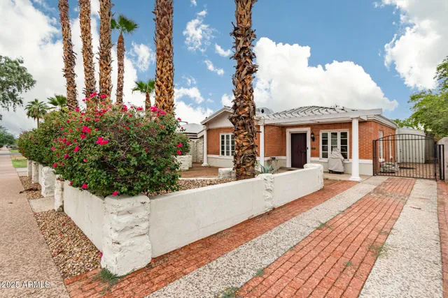 a front view of a house with a yard and fountain
