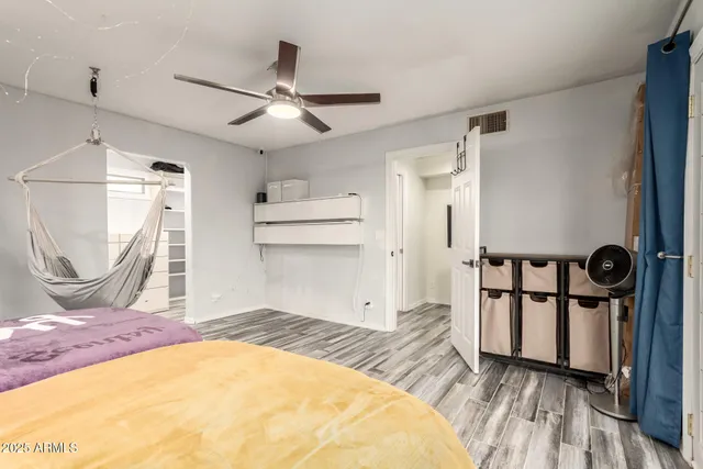 a view of a bedroom with wooden floor and ceiling fan