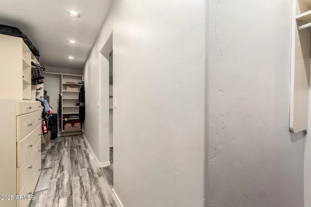 a view of walk in closet with clothes and shoes