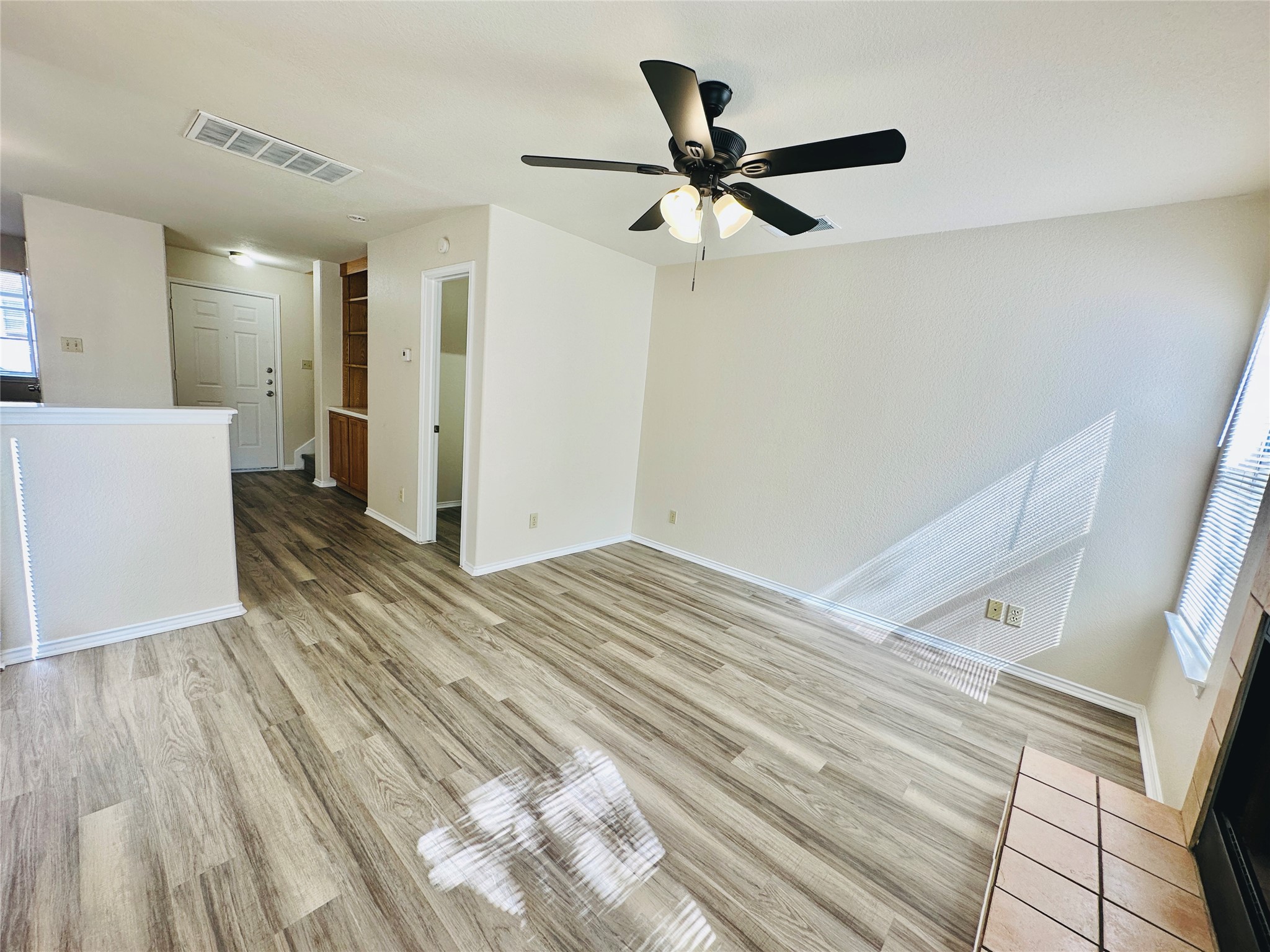 8814 Schick Road, Unit C Austin, TX 78729 - Photo 10 of 35 A living space offers light wood-look flooring and a ceiling fan for comfort.