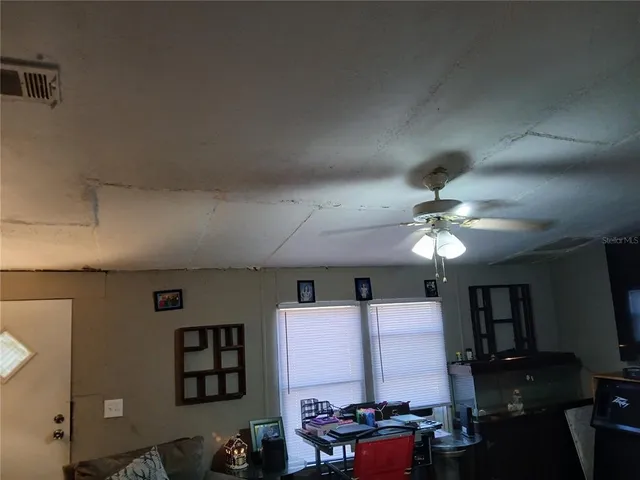 a view of backyard with wooden fence and a large tree