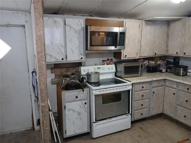 a kitchen with stainless steel appliances a stove a microwave a sink and cabinets
