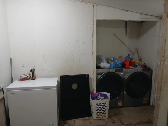 a utility room with dryer washer and shoe rack