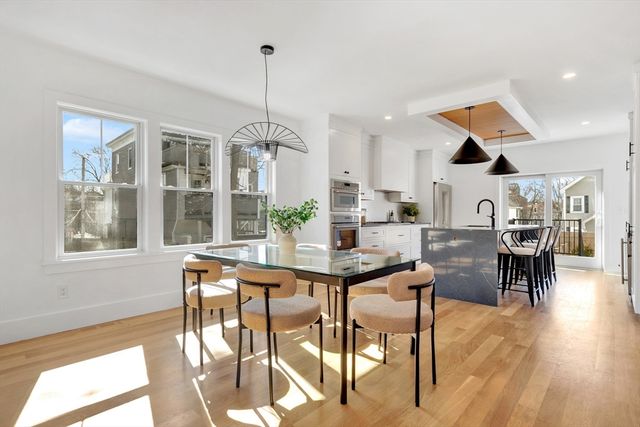 a kitchen with stainless steel appliances kitchen island granite countertop a table and chairs in it