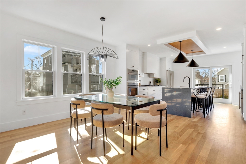 6 Berkeley Street Somerville, MA 02143 - Photo 11 of 41 a kitchen with stainless steel appliances kitchen island granite countertop a table and chairs in it