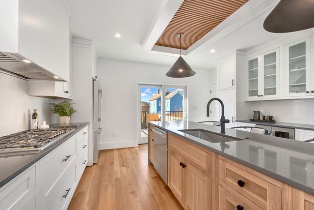 a large kitchen with stainless steel appliances granite countertop a stove and a sink