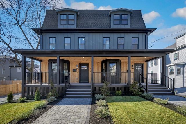 a view of a house with a small yard plants and large tree