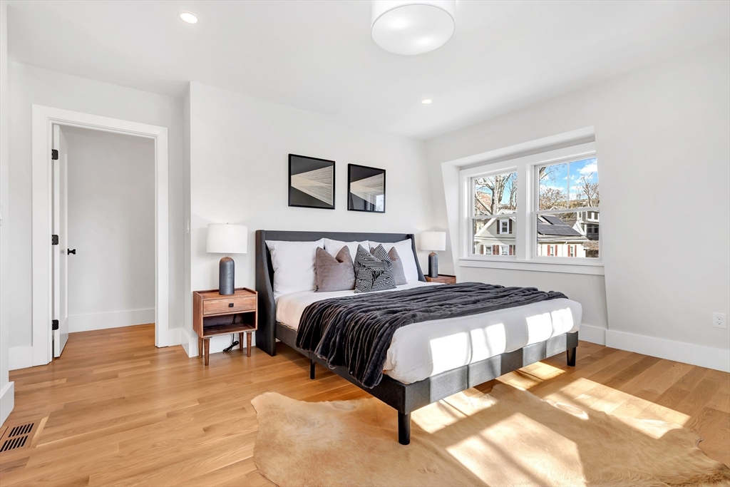 6 Berkeley Street Somerville, MA 02143 - Photo 27 of 41 a bedroom with a bed and a painting on the wall