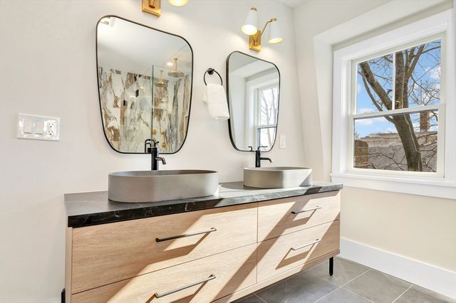 a bathroom with sinks a mirror and a window