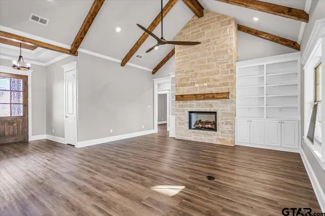 a view of an empty room with a fireplace and a window