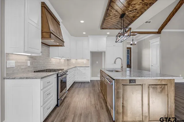 a kitchen with stainless steel appliances granite countertop a sink and cabinets