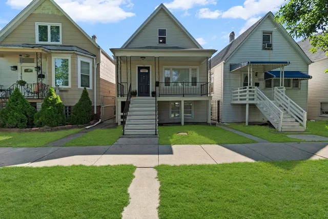 a front view of a house with a yard and potted plants