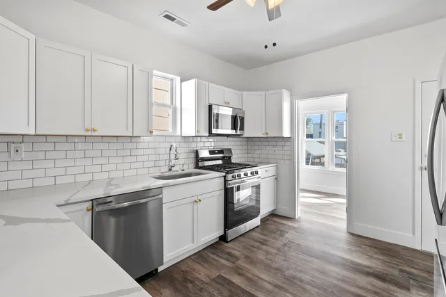 a kitchen with stainless steel appliances granite countertop a sink stove and refrigerator