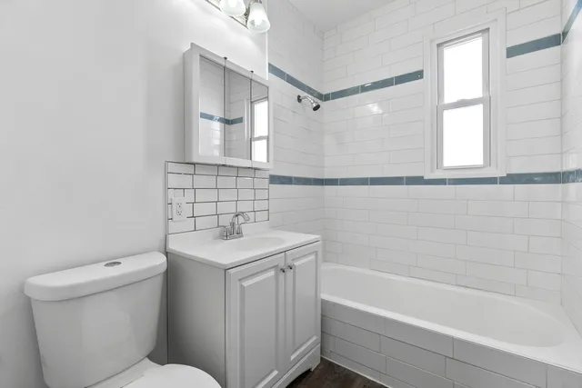 a bathroom with a sink toilet vanity and bathtub