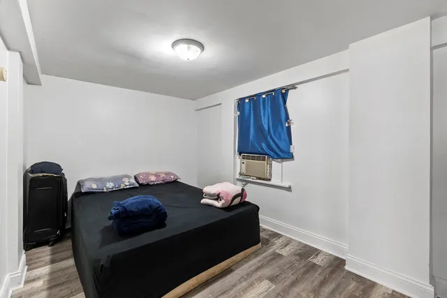 a bedroom with a bed and wooden floor