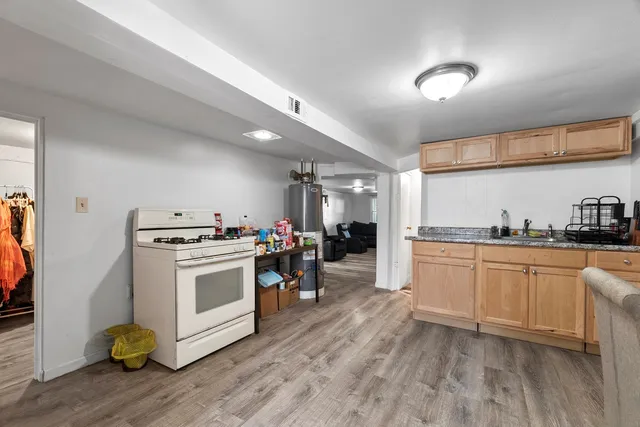 a kitchen with sink a stove and white cabinets