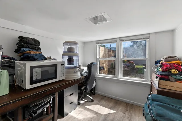 a view of a workspace with furniture and a window